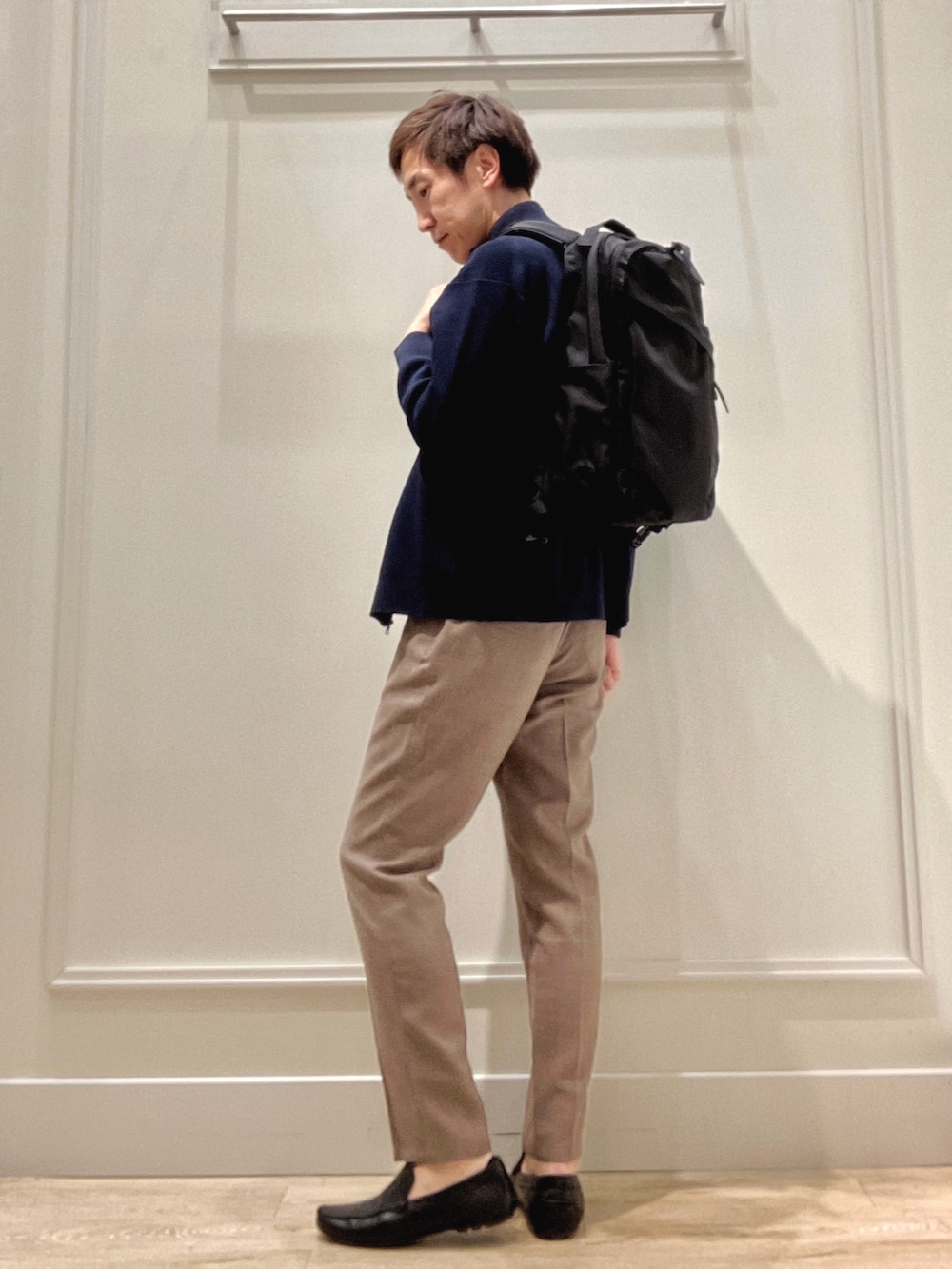 ブルー系のニット/セーター、ホワイト系のTシャツ/カットソー、ベージュ系のその他パンツを着用したメンズの冬コーディネートの3枚目の写真