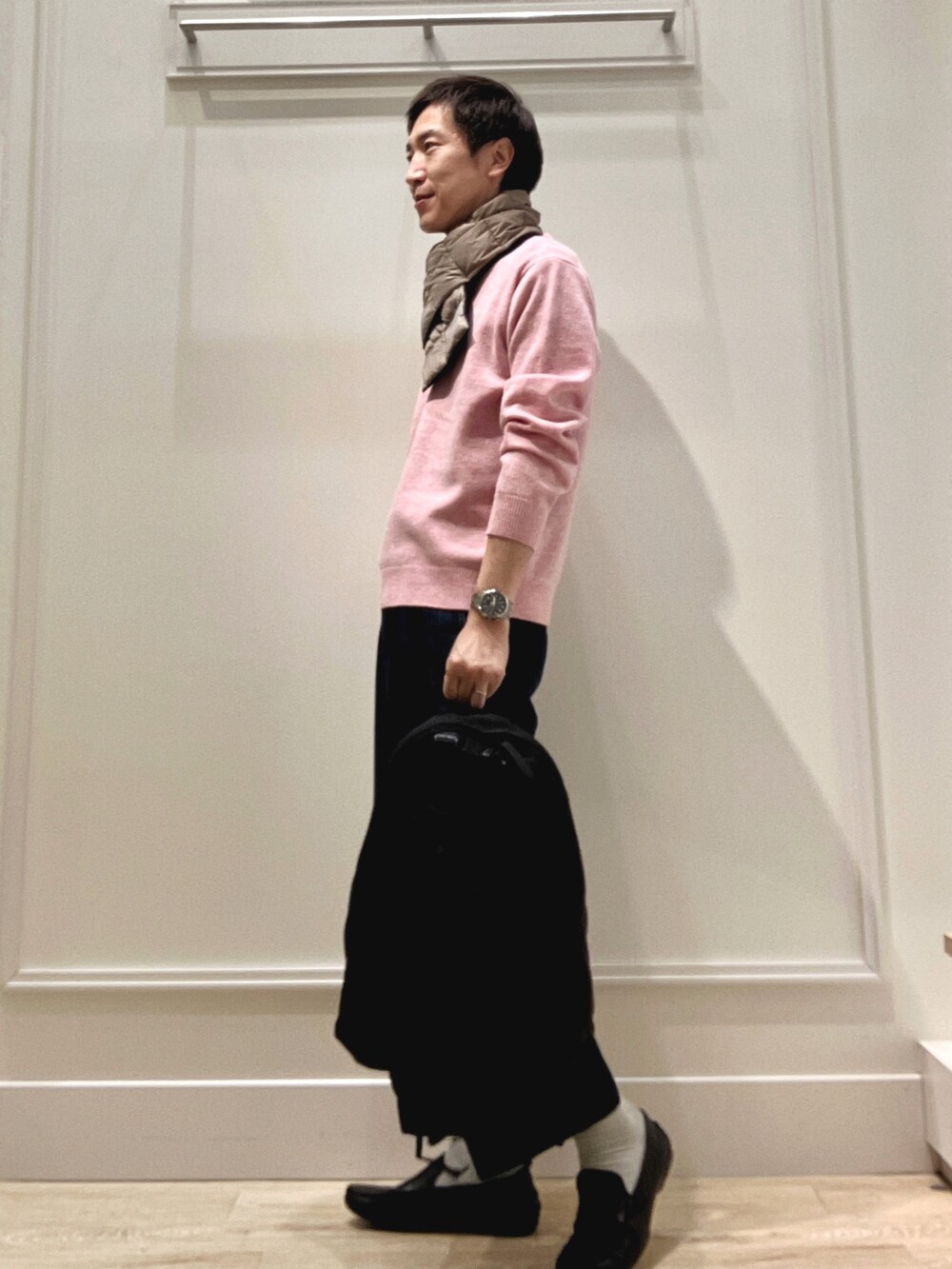 ピンク系のニット/セーター、ブラック系のバックパック/リュック、グリーン系のマフラーを着用したメンズの冬コーディネートの3枚目の写真