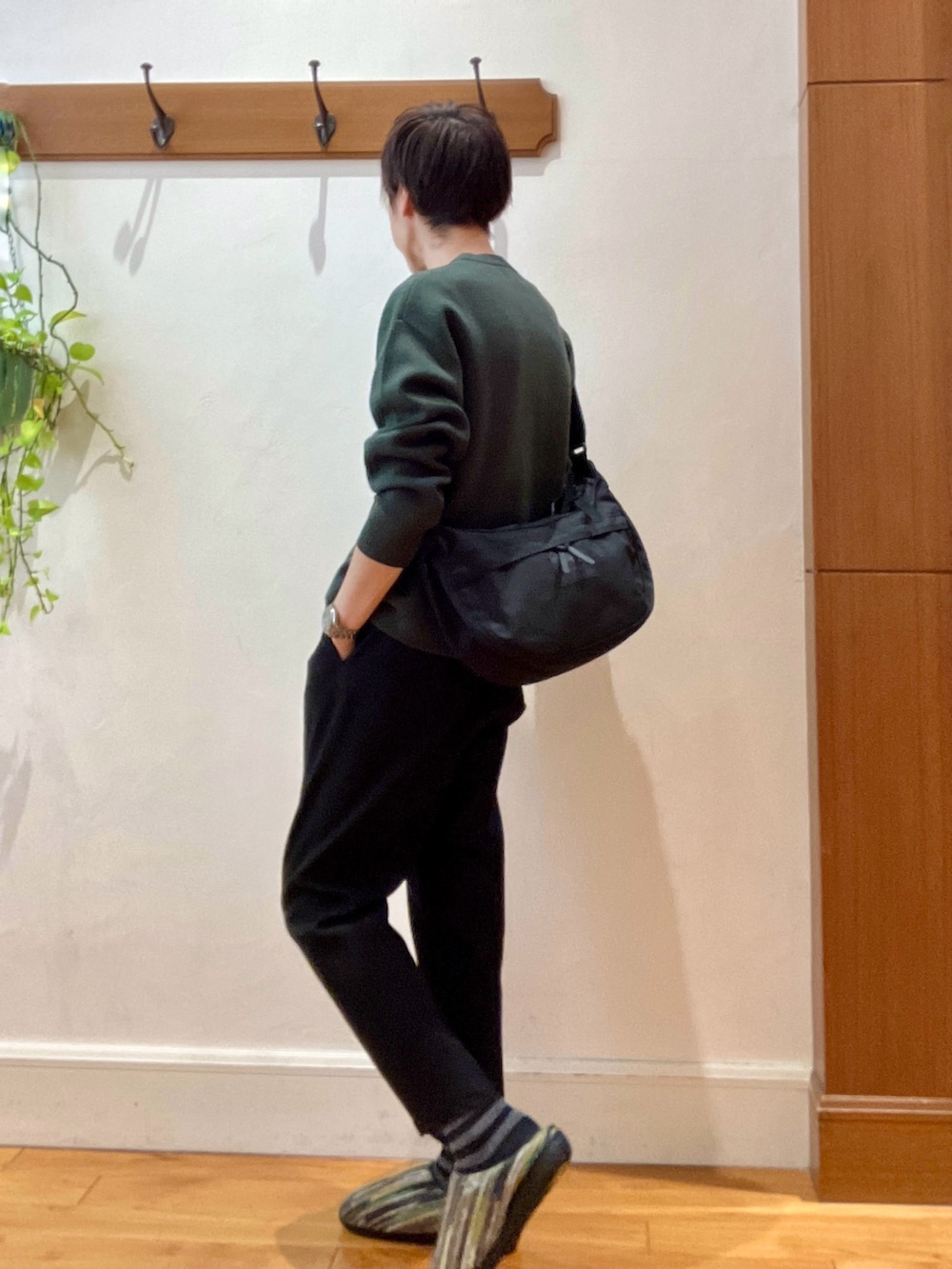 グリーン系のニット/セーター、ブラック系のショルダーバッグ、グリーン系のサンダルを着用したメンズの冬コーディネートの4枚目の写真