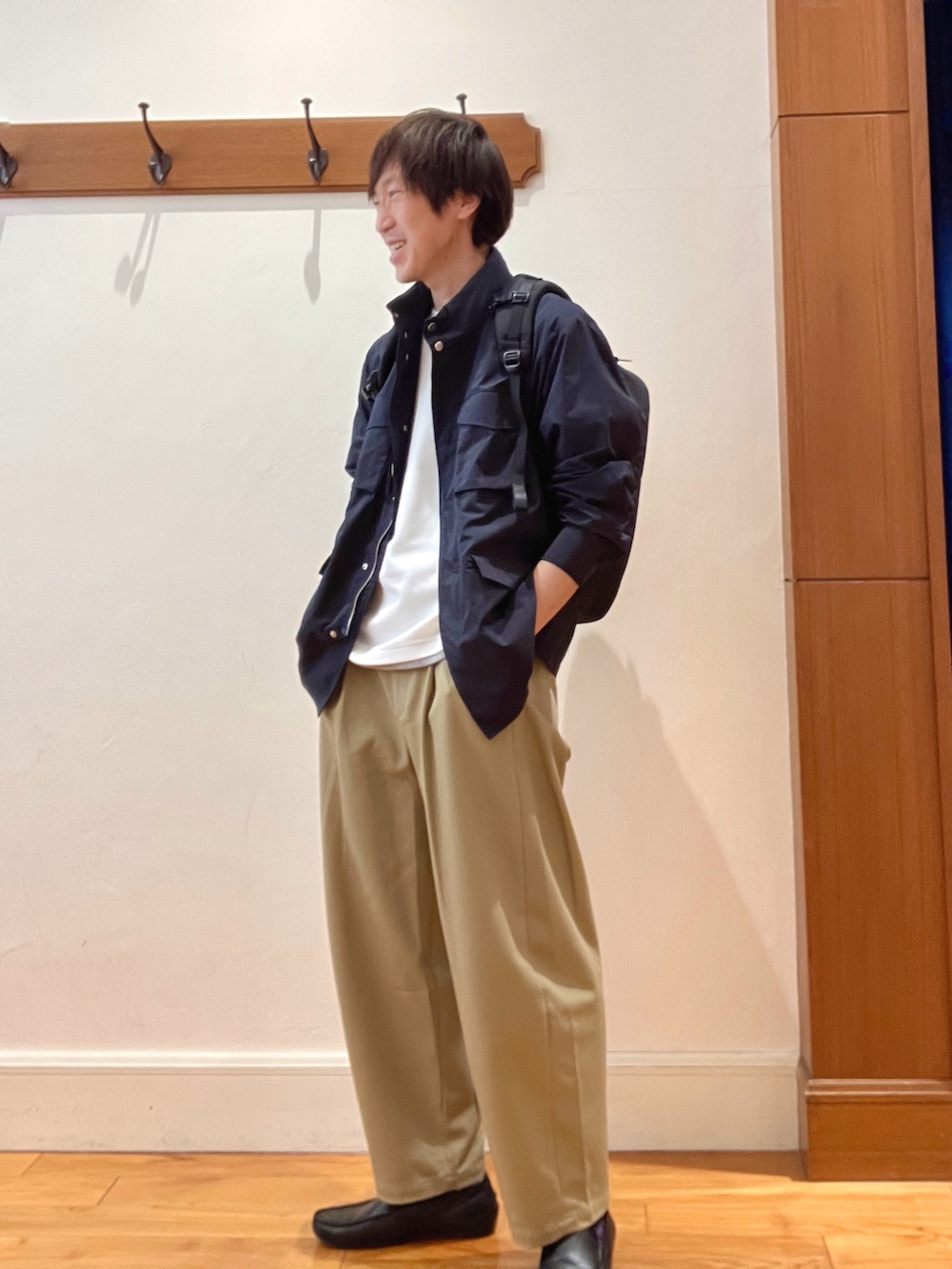 ブルー系のブルゾン、ホワイト系のTシャツ/カットソー、ブラック系のバックパック/リュックを着用したメンズの春コーディネートの2枚目の写真