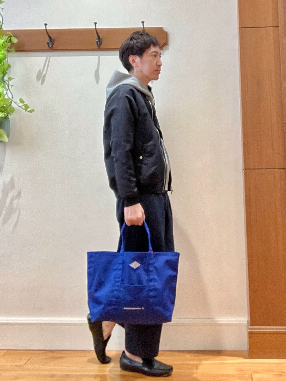 ブラック系のブルゾン、グレー系のパーカー、ブルー系のデニムパンツを着用したメンズの春コーディネートの5枚目の写真