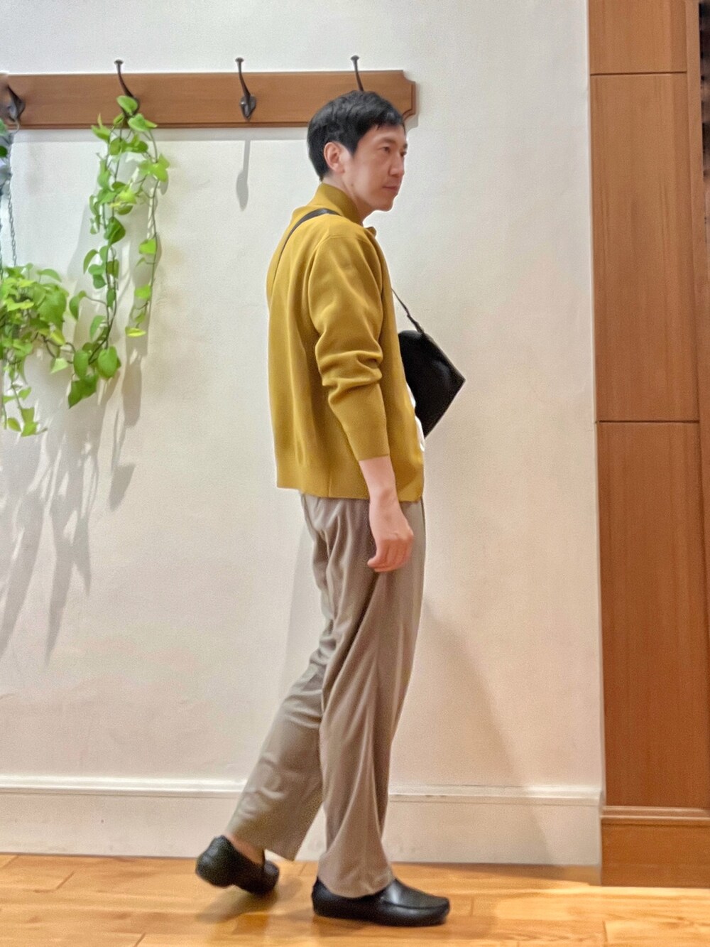 イエロー系のニット/セーター、ホワイト系のTシャツ/カットソー、ブラック系のショルダーバッグを着用したメンズの秋コーディネートの5枚目の写真