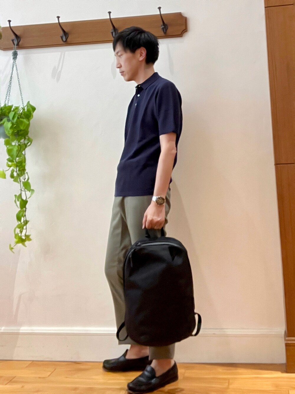 ブルー系のポロシャツ、ブラック系のバックパック/リュック、ブラック系のその他パンツを着用したメンズの春コーディネートの3枚目の写真