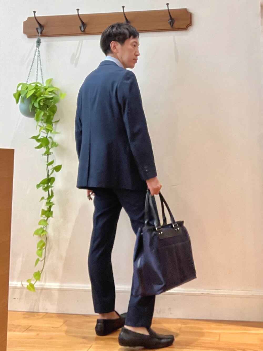 ブラック系のトートバッグ、ブルー系のスラックス、ベージュ系のネクタイを着用したメンズの秋コーディネートの5枚目の写真