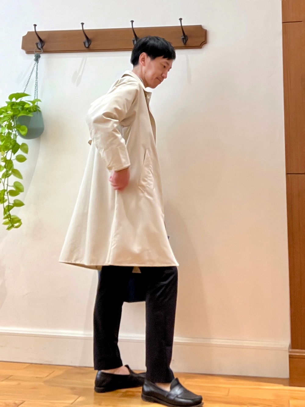 ホワイト系のステンカラーコート、グレー系のシャツ/ブラウス、レッド系のトートバッグを着用したメンズの春コーディネートの7枚目の写真