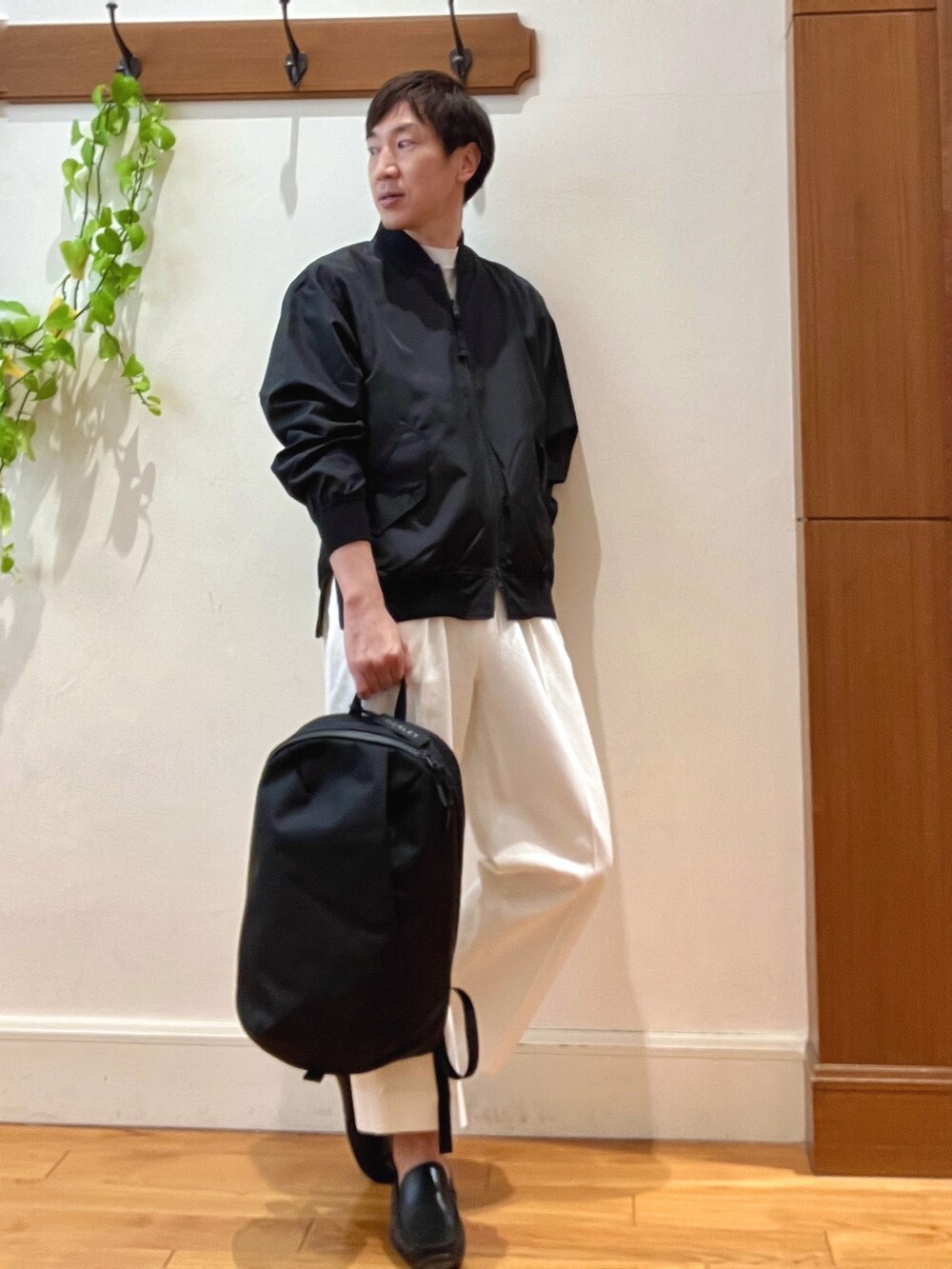 ブラック系のブルゾン、ホワイト系のデニムパンツ、ブラック系のバックパック/リュックを着用したメンズの冬コーディネートの7枚目の写真