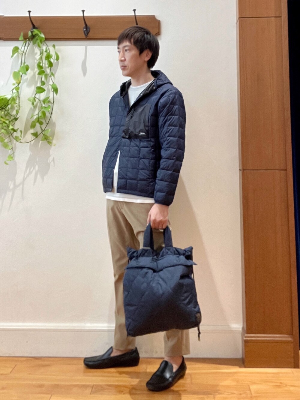 ブルー系のショルダーバッグ、グレー系のTシャツ/カットソー、ブルー系のダウンジャケット/コートを着用したメンズの秋コーディネートの3枚目の写真
