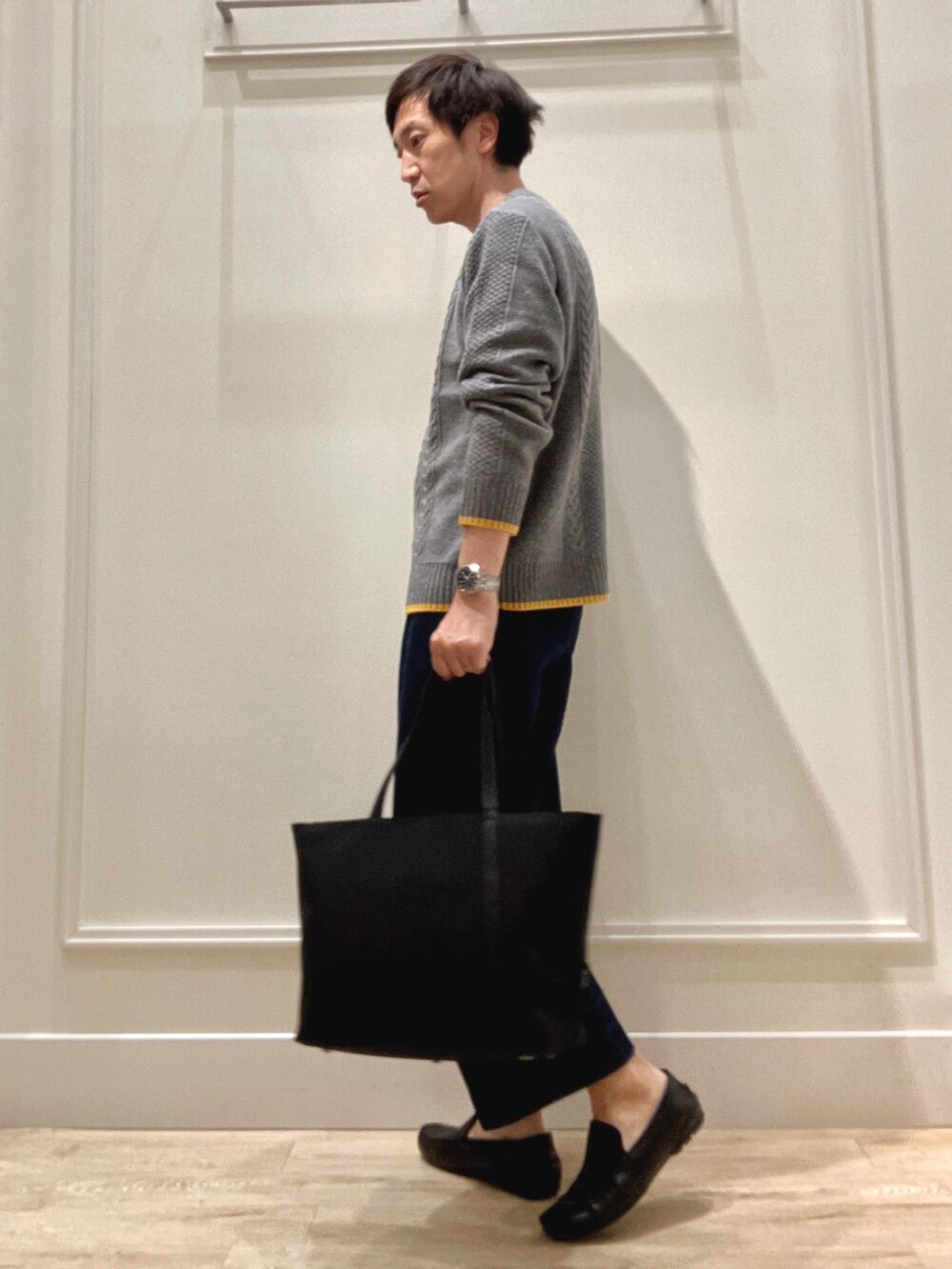 グレー系のニット/セーター、グレー系のトートバッグを着用したメンズの秋コーディネートの3枚目の写真
