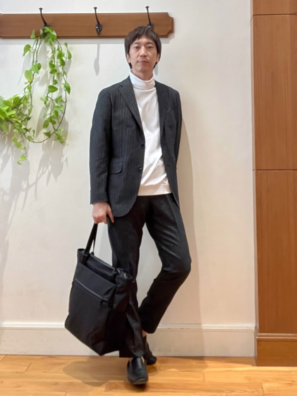 グレー系のテーラードジャケット、ホワイト系のTシャツ/カットソー、グレー系のスラックスを着用したメンズの秋コーディネートの7枚目の写真