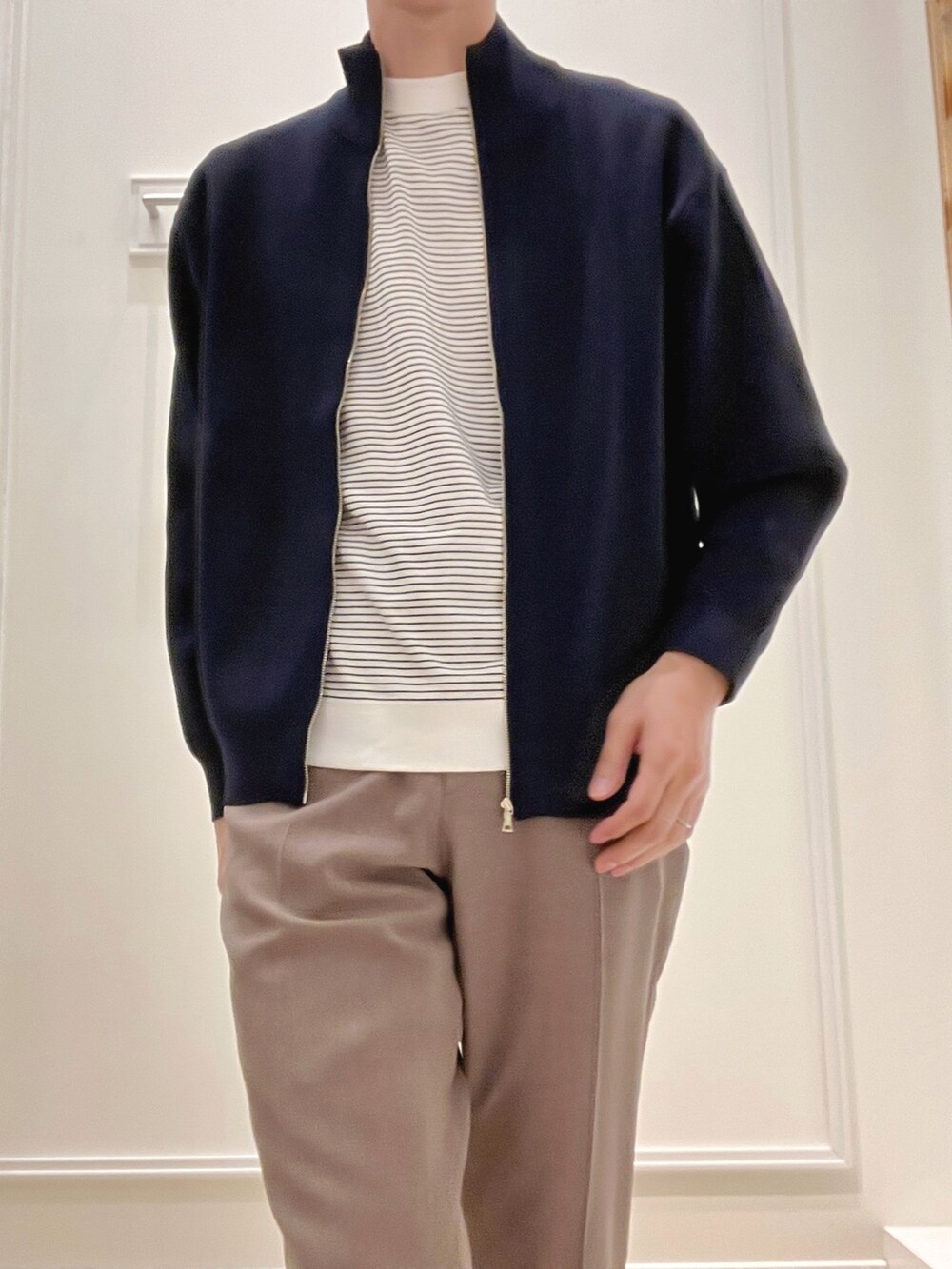 ブルー系のニット/セーター、ホワイト系のTシャツ/カットソー、ベージュ系のその他パンツを着用したメンズの冬コーディネートの8枚目の写真