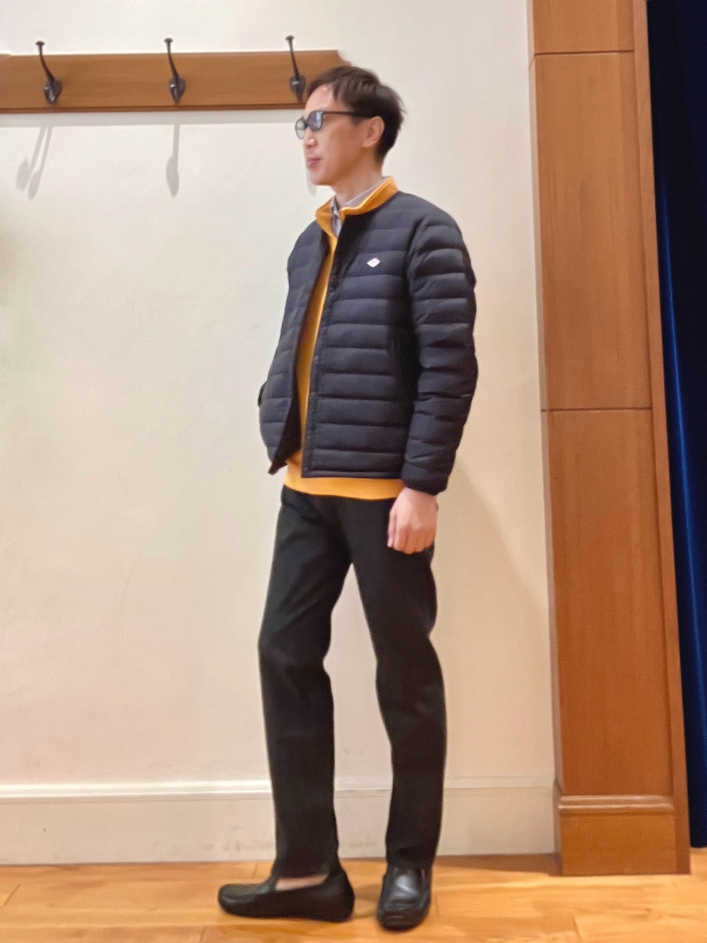 オレンジ系のスウェット、ブルー系のシャツ/ブラウス、ブラック系のダウンジャケット/コートを着用したメンズの秋コーディネートの2枚目の写真