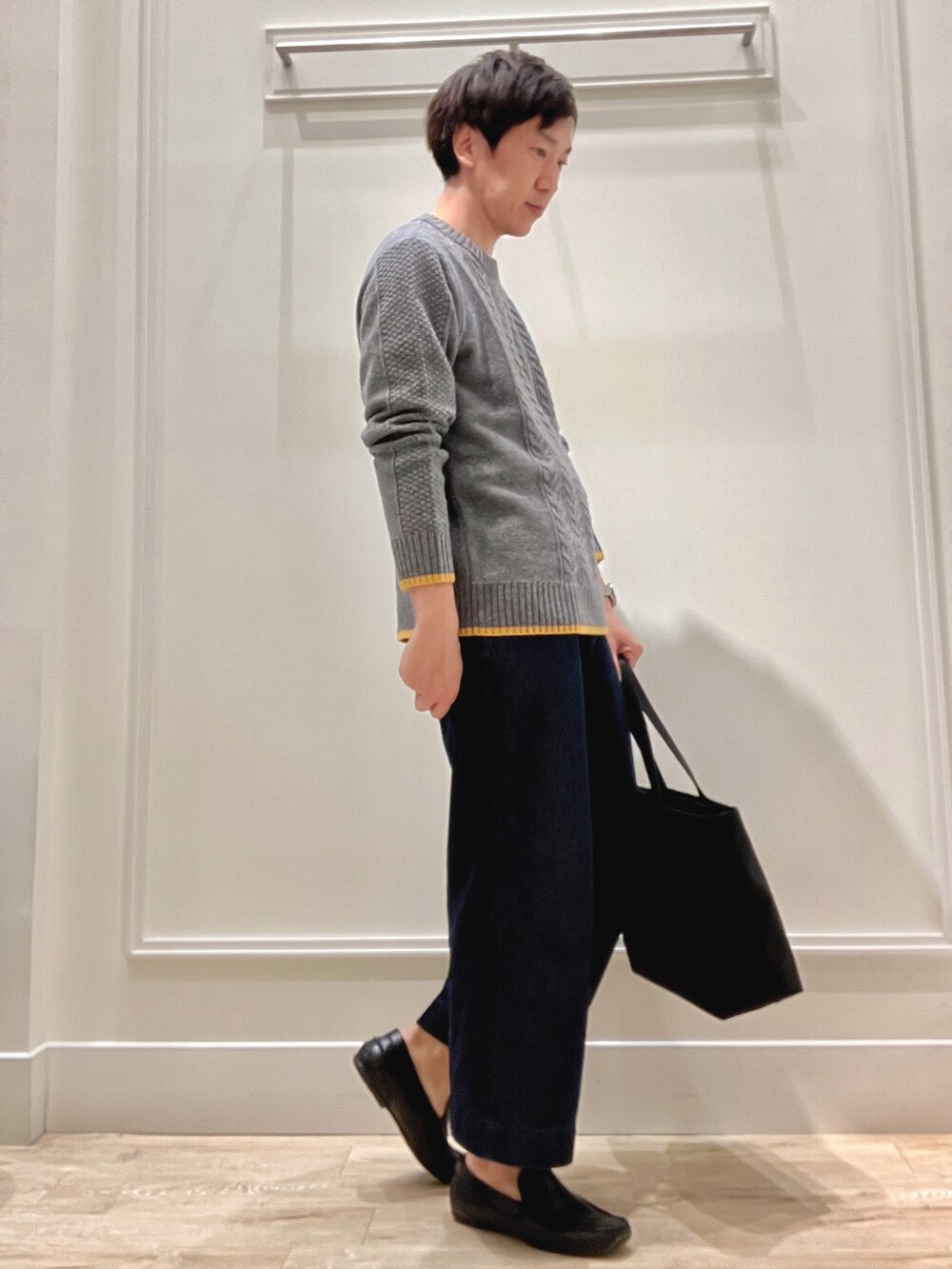 グレー系のニット/セーター、グレー系のトートバッグを着用したメンズの秋コーディネートの5枚目の写真