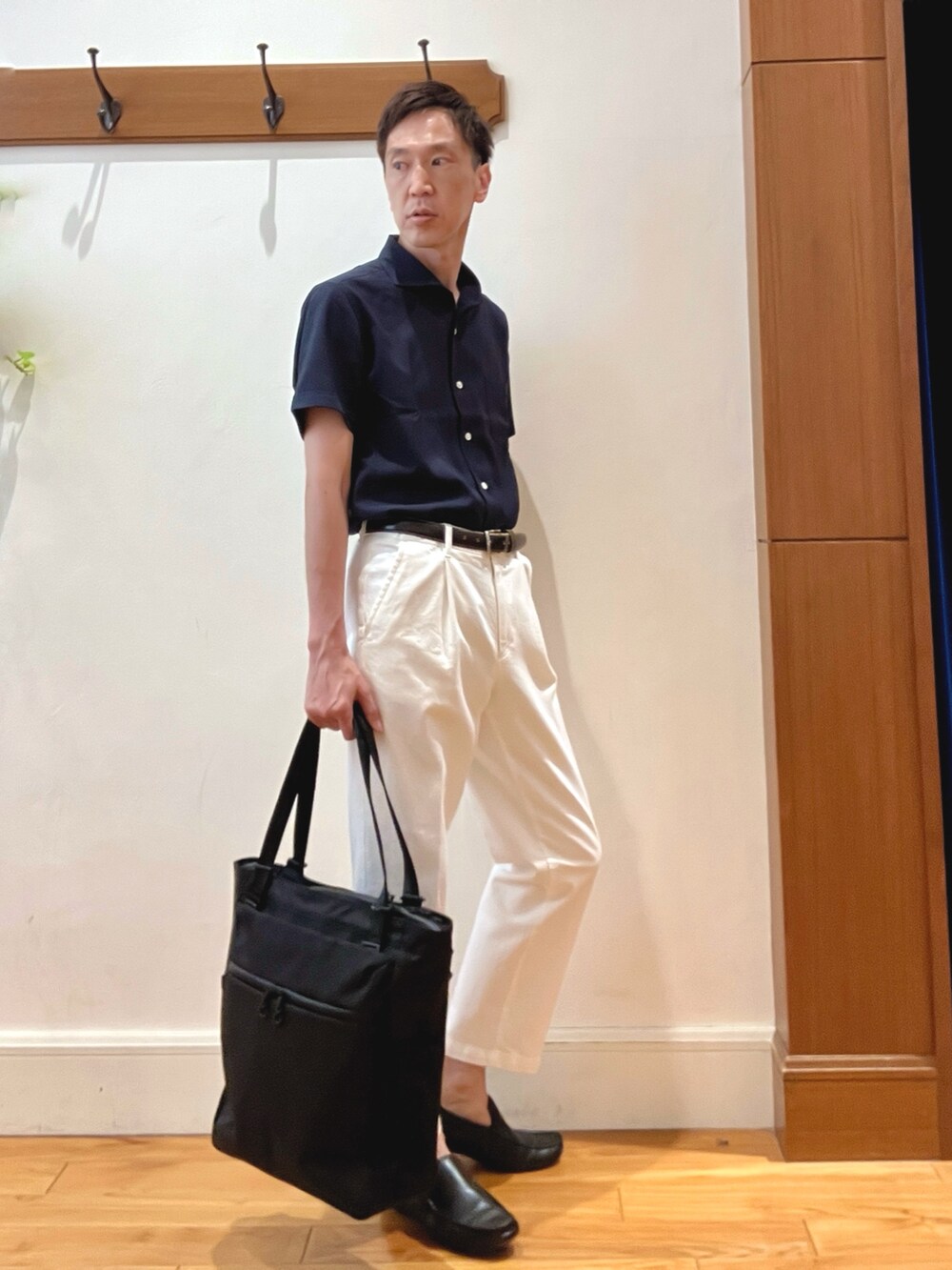 ホワイト系のデニムパンツ、ブルー系のビジネスシャツ、ブラック系のトートバッグを着用したメンズの夏コーディネートの5枚目の写真