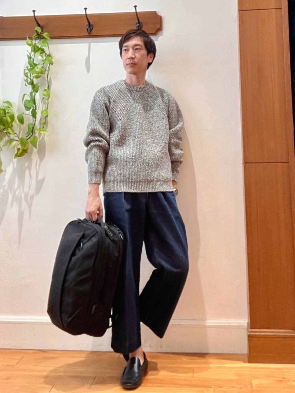 グレー系のニット/セーター、ブラック系のバックパック/リュックを着用したメンズの秋コーディネートの7枚目の写真