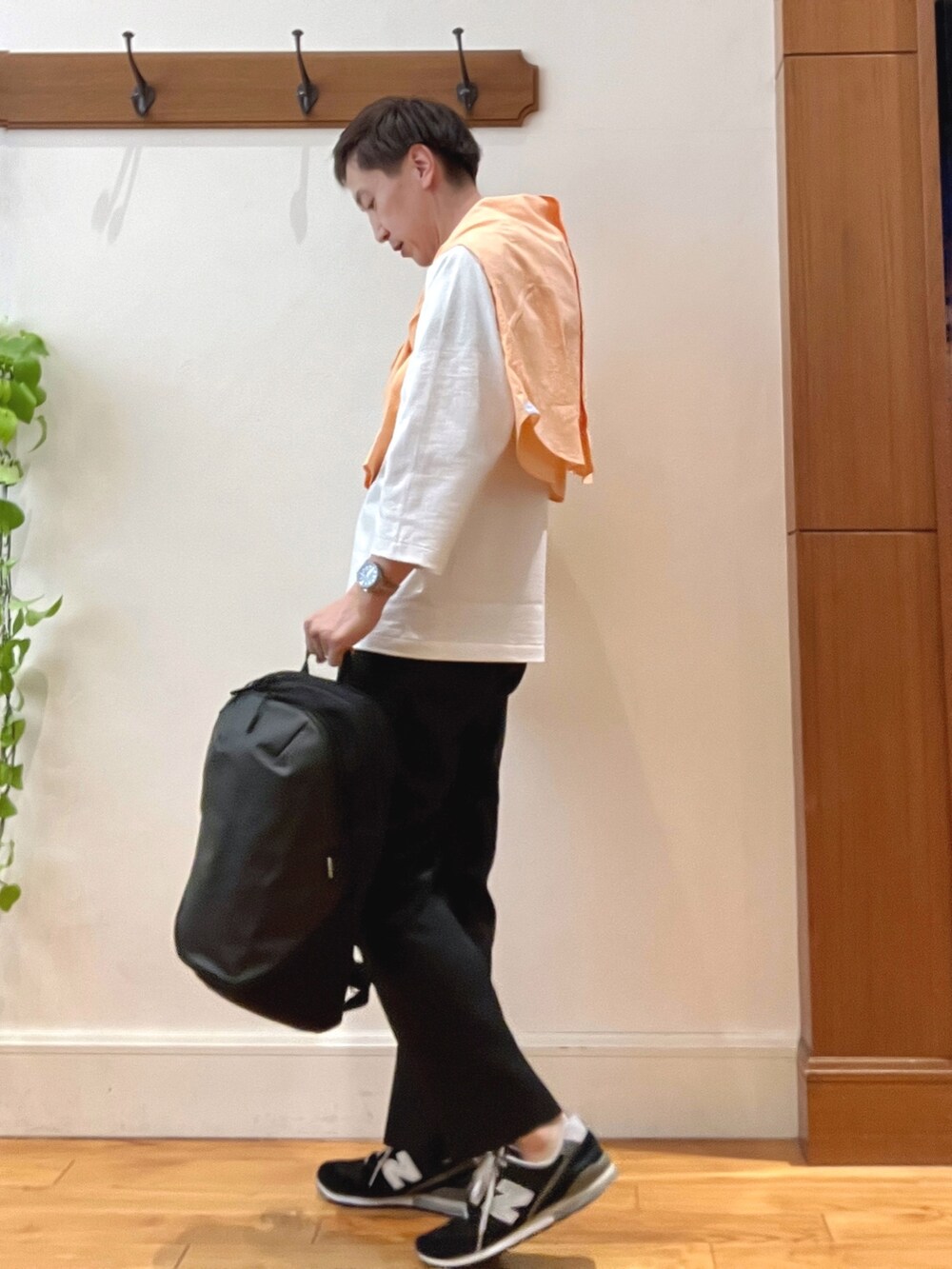 オレンジ系のシャツ/ブラウス、ブラック系のその他パンツ、グレー系のバックパック/リュックを着用したメンズの春コーディネートの3枚目の写真