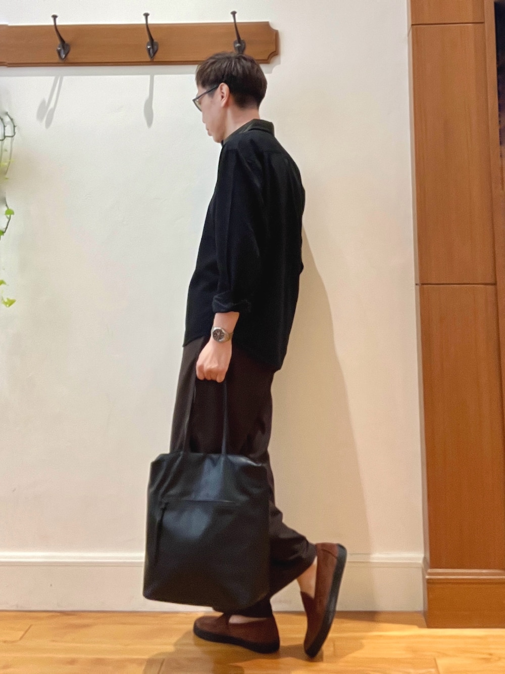 ブラック系のシャツ/ブラウス、ブラウン系のスニーカー、ブラック系のトートバッグを着用したメンズの秋コーディネートの3枚目の写真