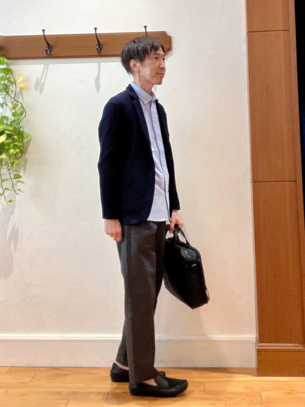 ブルー系のカーディガン/ボレロ、ブルー系のシャツ/ブラウス、ブラック系のビジネスバッグを着用したメンズの秋コーディネートの6枚目の写真