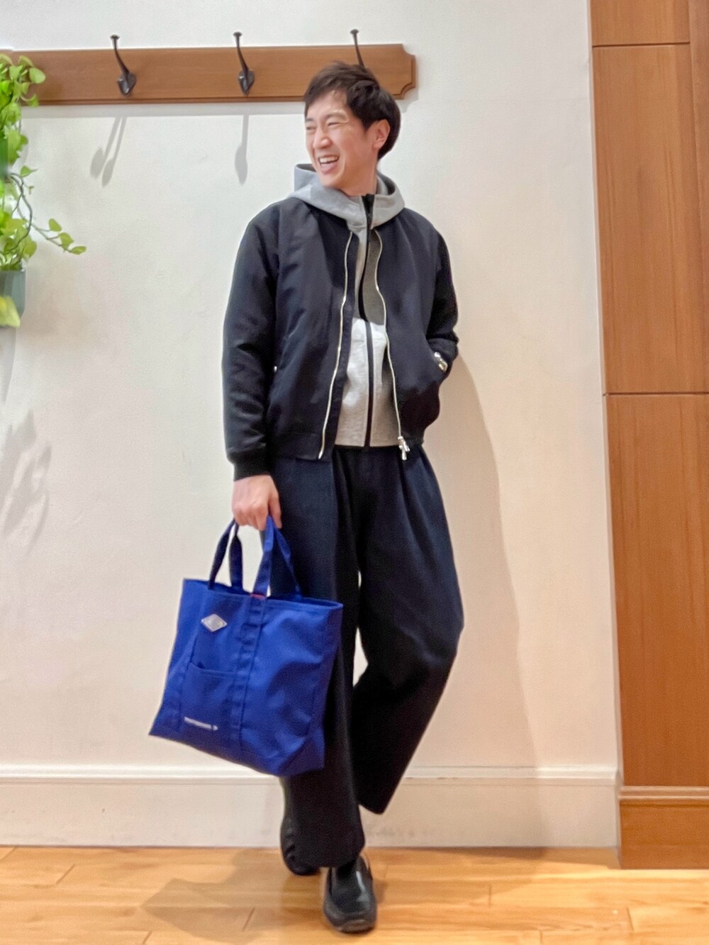 ブラック系のブルゾン、グレー系のパーカー、ブルー系のデニムパンツを着用したメンズの春コーディネートの6枚目の写真