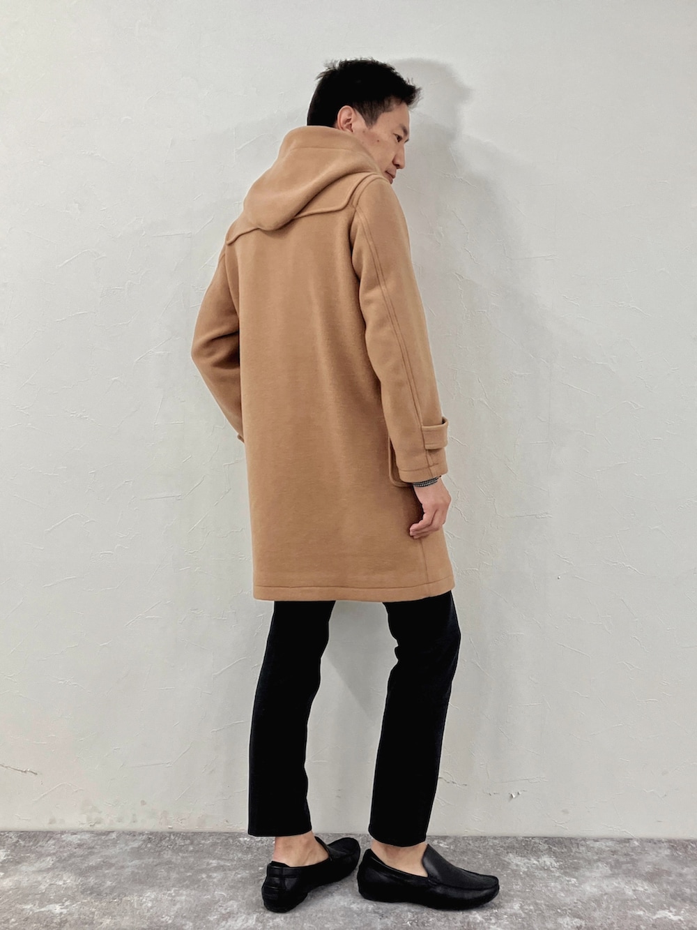 ブラック系のダッフルコートを着用したメンズの冬コーディネートの5枚目の写真