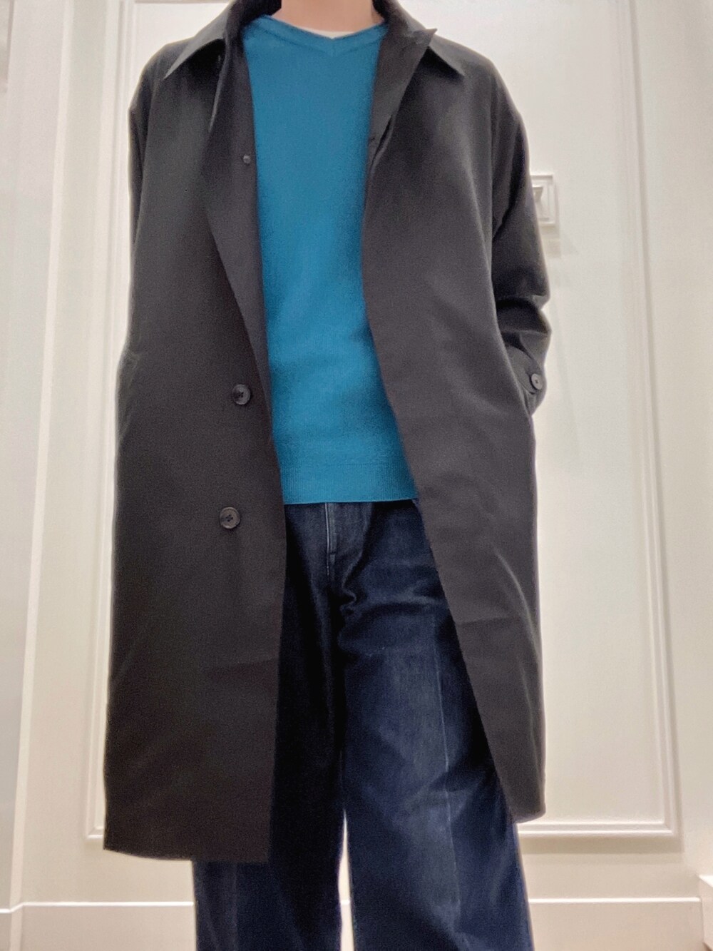 ブラック系のステンカラーコート、グリーン系のニット/セーターを着用したメンズの冬コーディネートの5枚目の写真