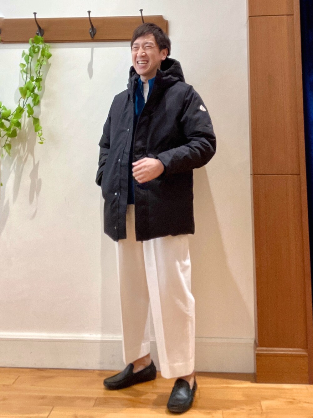 ホワイト系のTシャツ/カットソー、ブラック系のダウンジャケット/コート、ブルー系のカーディガン/ボレロを着用したメンズの冬コーディネートの2枚目の写真