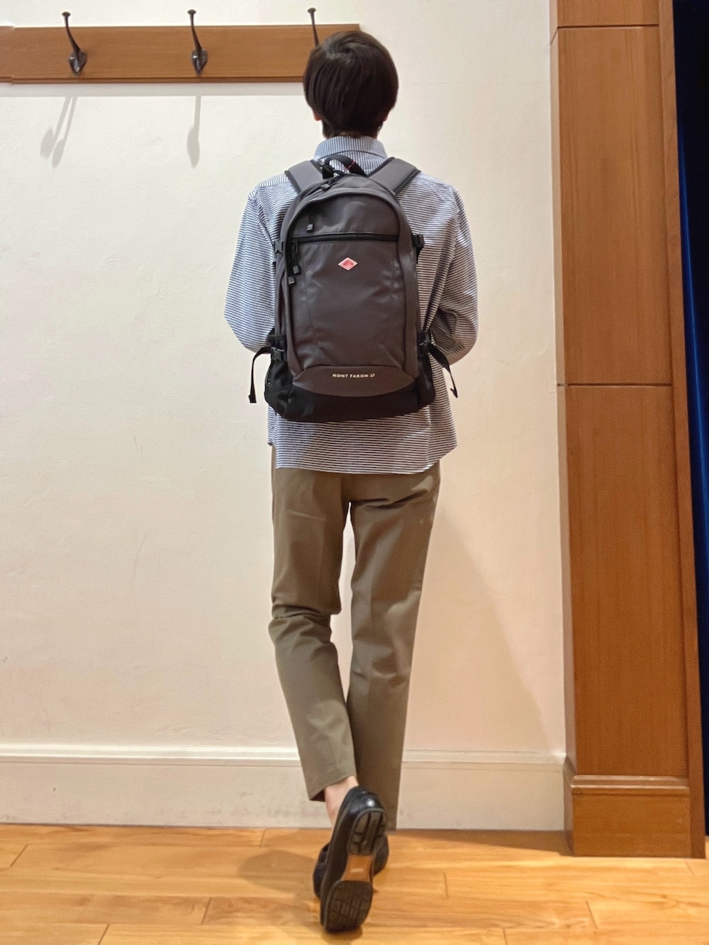 ブルー系のシャツ/ブラウス、グレー系のバックパック/リュック、グリーン系のチノパンツを着用したメンズの春コーディネートの4枚目の写真