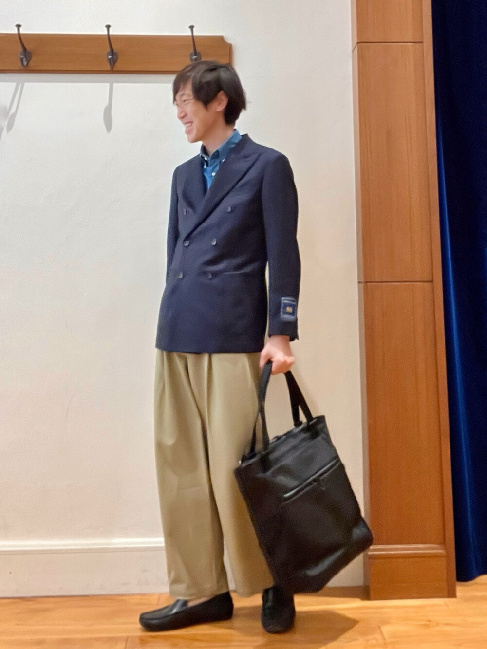 ブルー系のテーラードジャケット、ブラック系のトートバッグを着用したメンズの春コーディネートの4枚目の写真