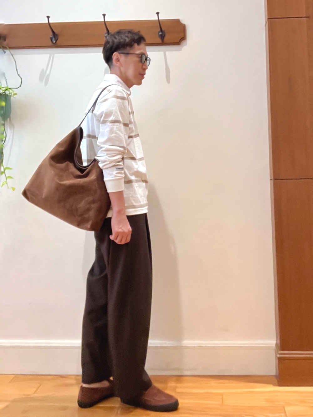 イエロー系のショルダーバッグ、ブラウン系のスニーカー、ホワイト系のTシャツ/カットソーを着用したメンズの秋コーディネートの7枚目の写真