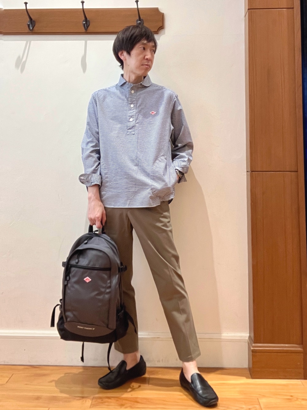 ブルー系のシャツ/ブラウス、グレー系のバックパック/リュック、グリーン系のチノパンツを着用したメンズの春コーディネートの8枚目の写真