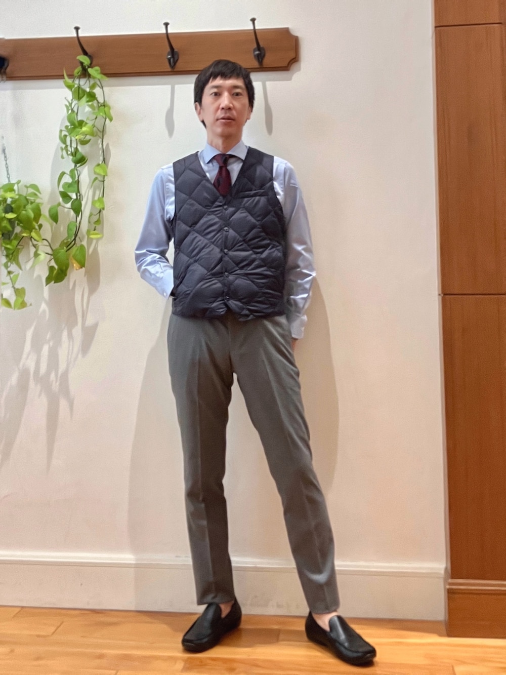 グレー系のその他パンツ、ブルー系のビジネスシャツ、ブルー系のダウンベストを着用したメンズの秋コーディネートの8枚目の写真