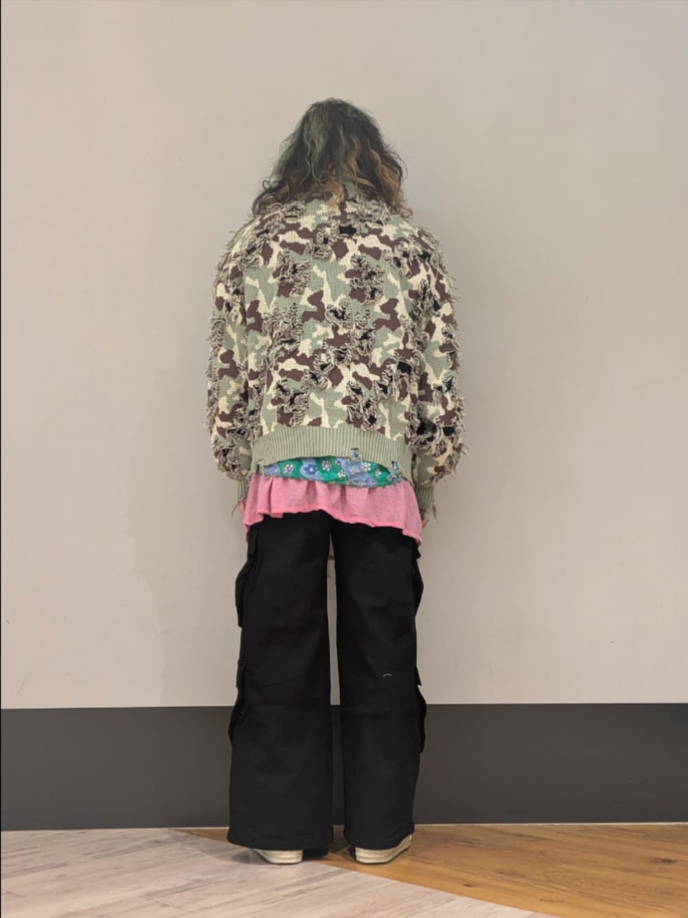 グリーン系のニット/セーター、ブラック系のカーゴパンツを着用したメンズの冬コーディネートの2枚目の写真