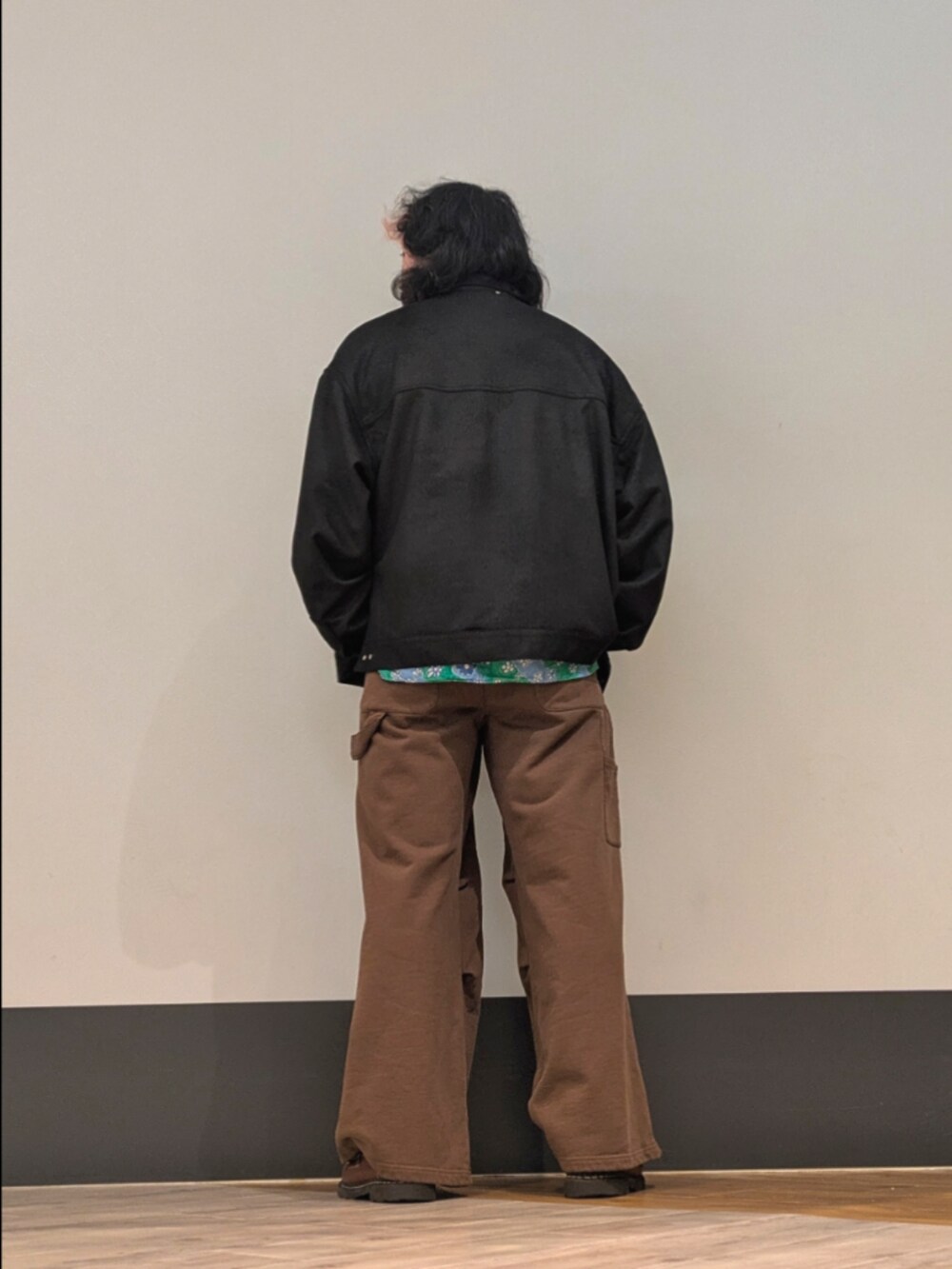 ブラック系のカバーオール、ブラウン系のスウェットパンツを着用したメンズの秋コーディネートの2枚目の写真