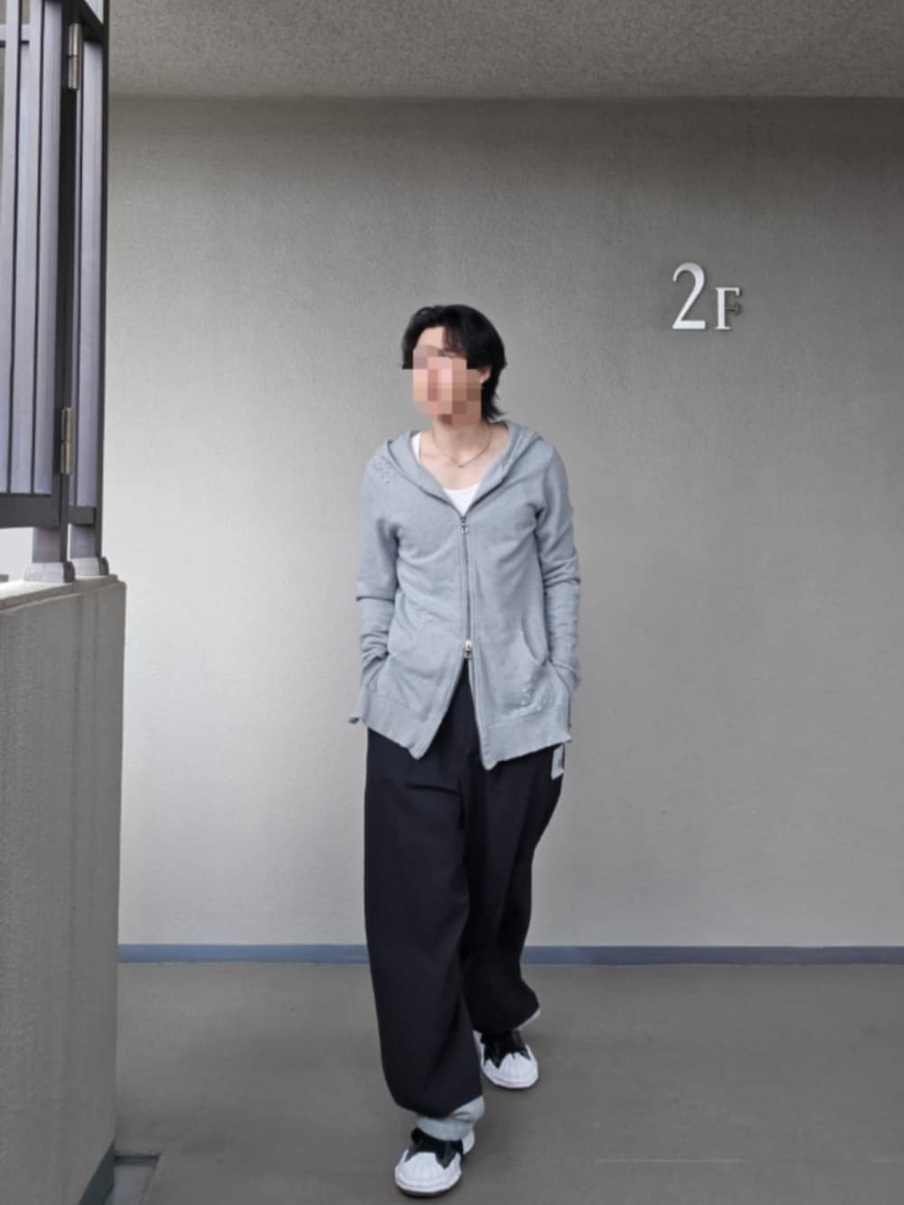 グレー系のパーカー、ブラック系のテーラードジャケット、ブラック系のその他パンツを着用したメンズの春コーディネートの2枚目の写真