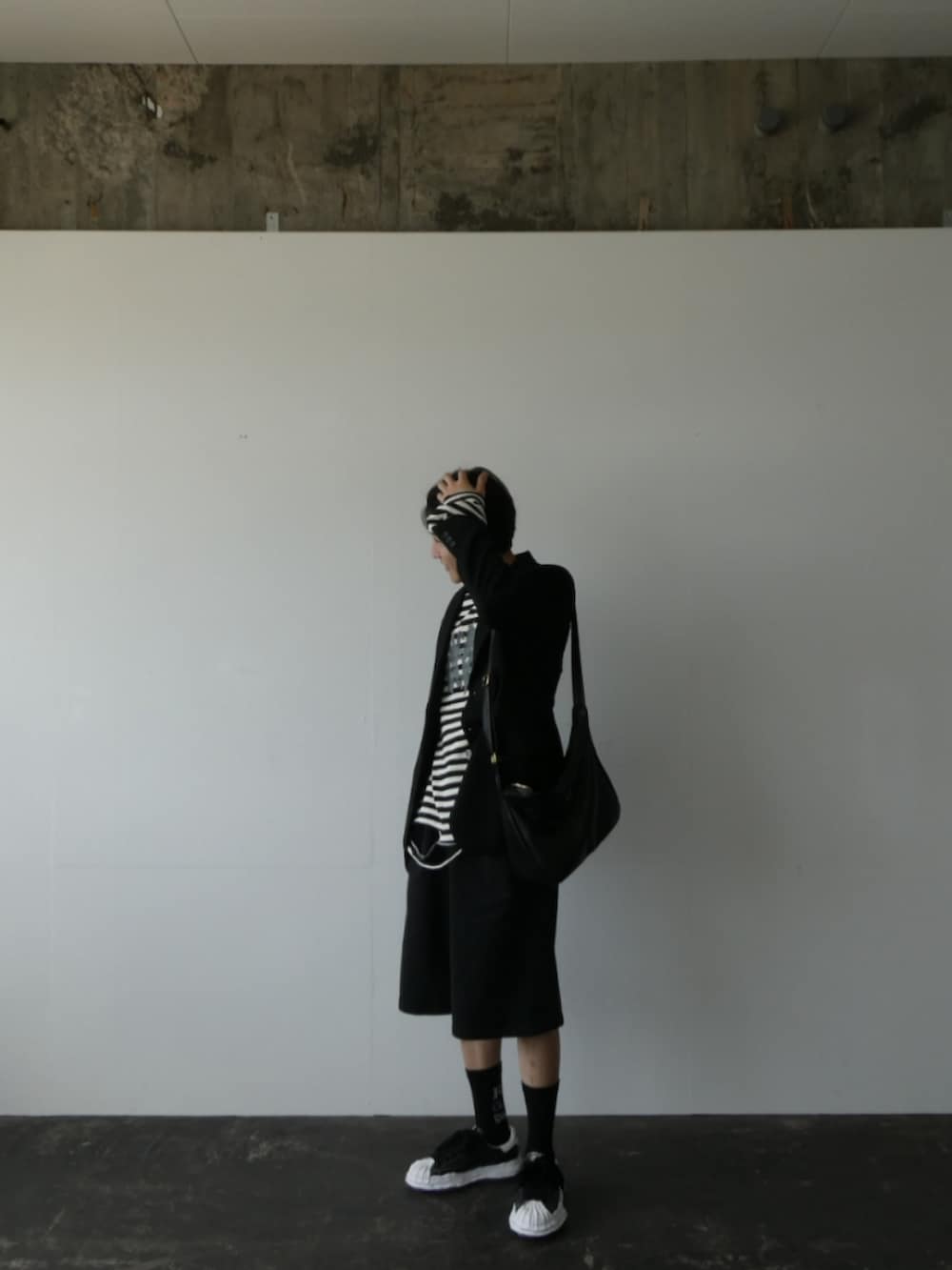 ブラック系のテーラードジャケット、ブラック系のTシャツ/カットソー、ブラック系のショルダーバッグを着用したメンズの春コーディネートの2枚目の写真