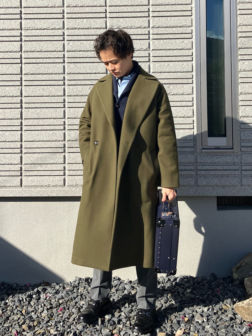 ブルー系のニット/セーター、ブルー系のビジネスシャツ、グリーン系のステンカラーコートを着用したメンズの冬コーディネートの3枚目の写真