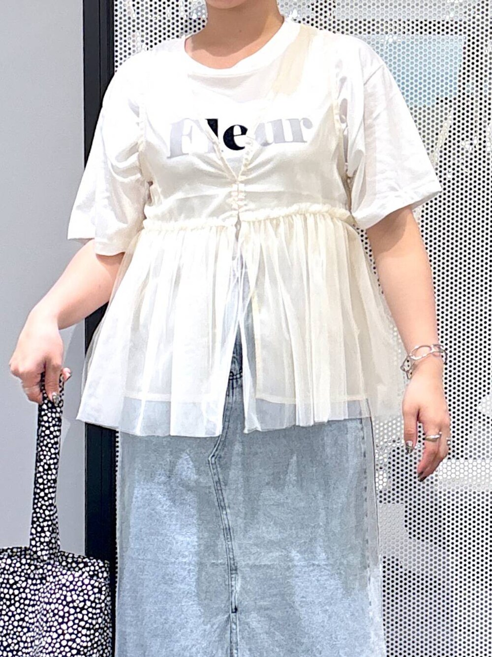 ブラック系のスニーカー、ブルー系のデニムスカート、ホワイト系のTシャツ/カットソーを着用したレディースの春コーディネートの4枚目の写真