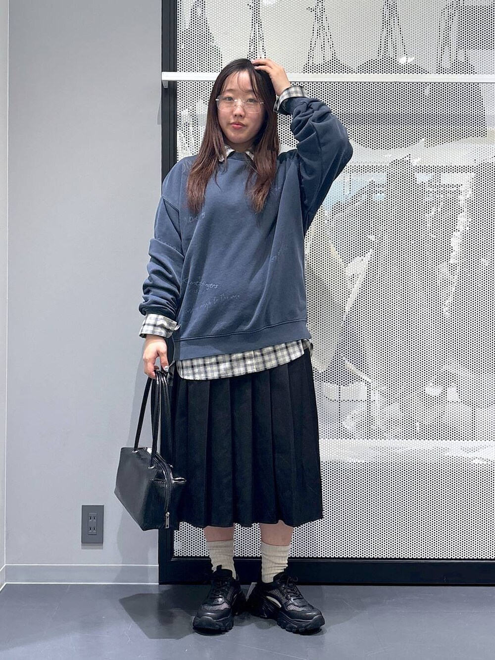 ブラック系のスカート、ブラック系のスニーカー、ベージュ系のシャツ/ブラウスを着用したレディースの冬コーディネートの6枚目の写真