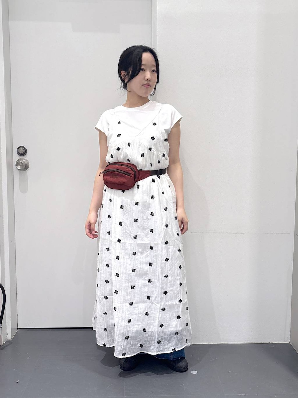 レッド系のボディバッグ/ウエストポーチ、ホワイト系のワンピース、ブルー系のデニムパンツを着用したレディースの夏コーディネートの4枚目の写真