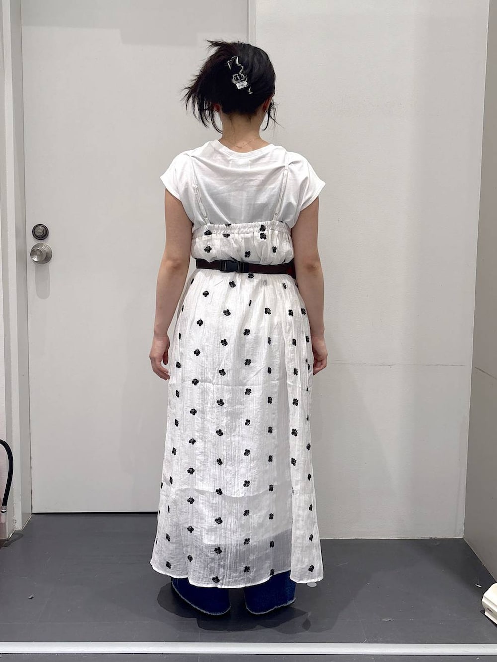 レッド系のボディバッグ/ウエストポーチ、ホワイト系のワンピース、ブルー系のデニムパンツを着用したレディースの夏コーディネートの3枚目の写真