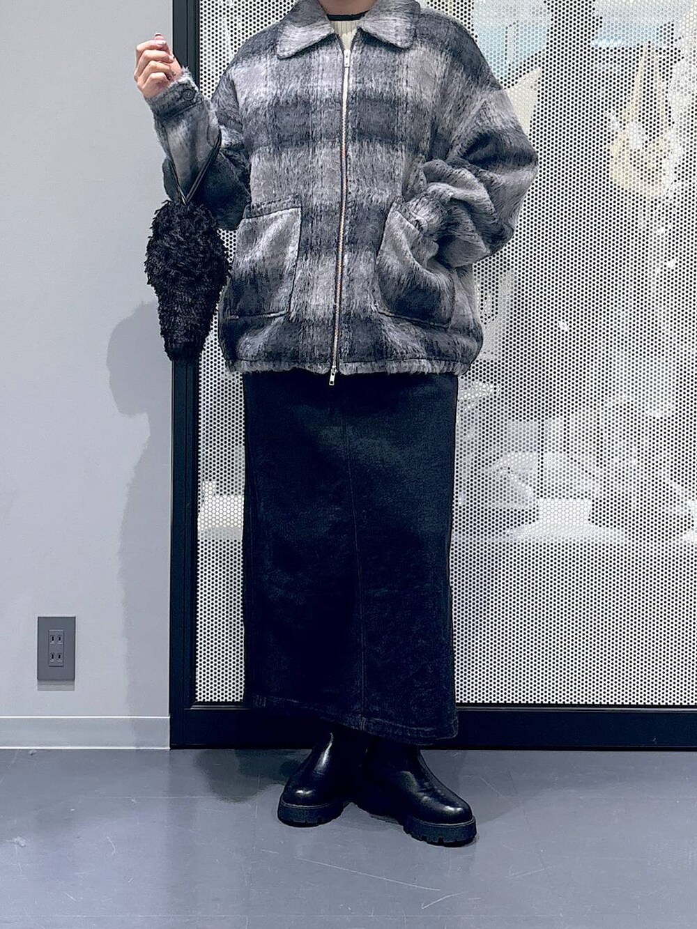 グレー系のジャンパースカート、ブラック系のショルダーバッグ、ブラック系のブーツを着用したレディースの冬コーディネートの5枚目の写真