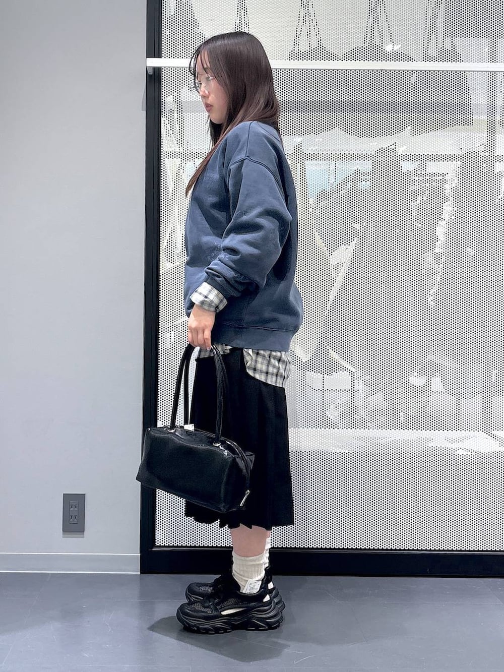 ブラック系のスカート、ブラック系のスニーカー、ベージュ系のシャツ/ブラウスを着用したレディースの冬コーディネートの2枚目の写真