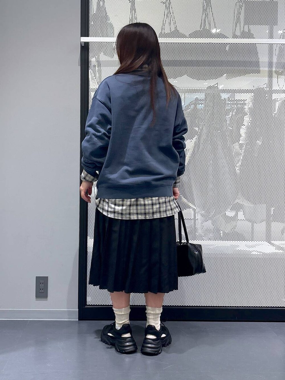 ブラック系のスカート、ブラック系のスニーカー、ベージュ系のシャツ/ブラウスを着用したレディースの冬コーディネートの3枚目の写真