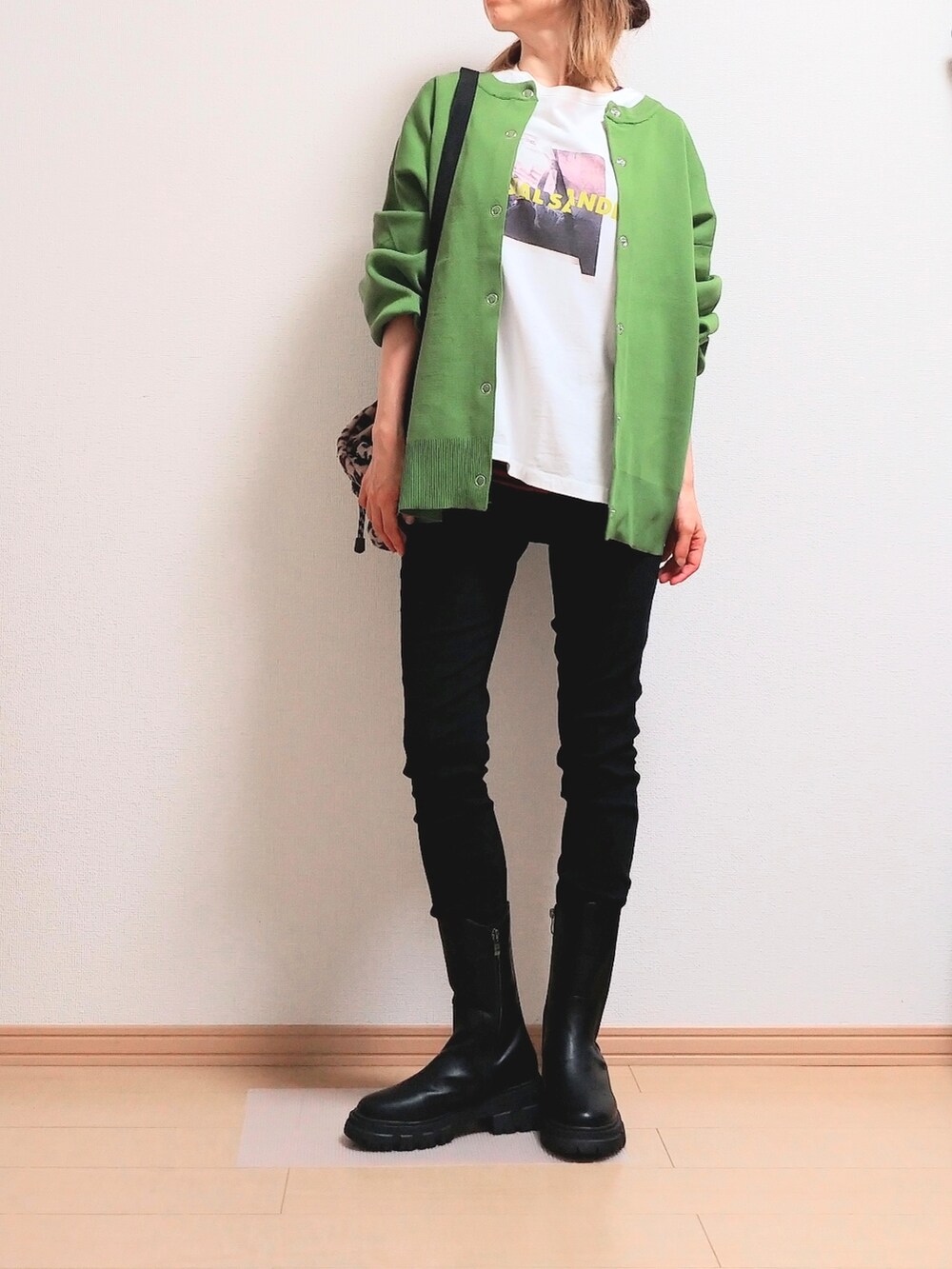 グリーン系のカーディガン/ボレロ、ブラック系のブーツを着用したレディースの秋コーディネートの2枚目の写真