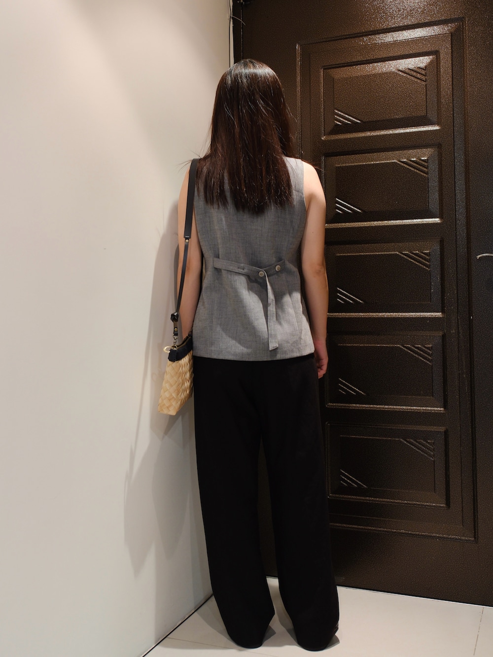 ブラック系のスラックス、グレー系のスーツベスト、ブラック系のローファーを着用したレディースの夏コーディネートの2枚目の写真