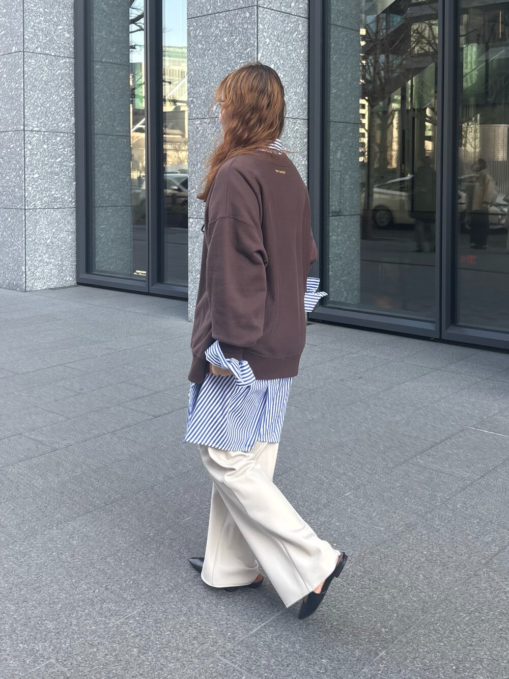 ブラウン系のスウェット、ブルー系のシャツ/ブラウス、ホワイト系のスラックスを着用したレディースの冬コーディネートの5枚目の写真