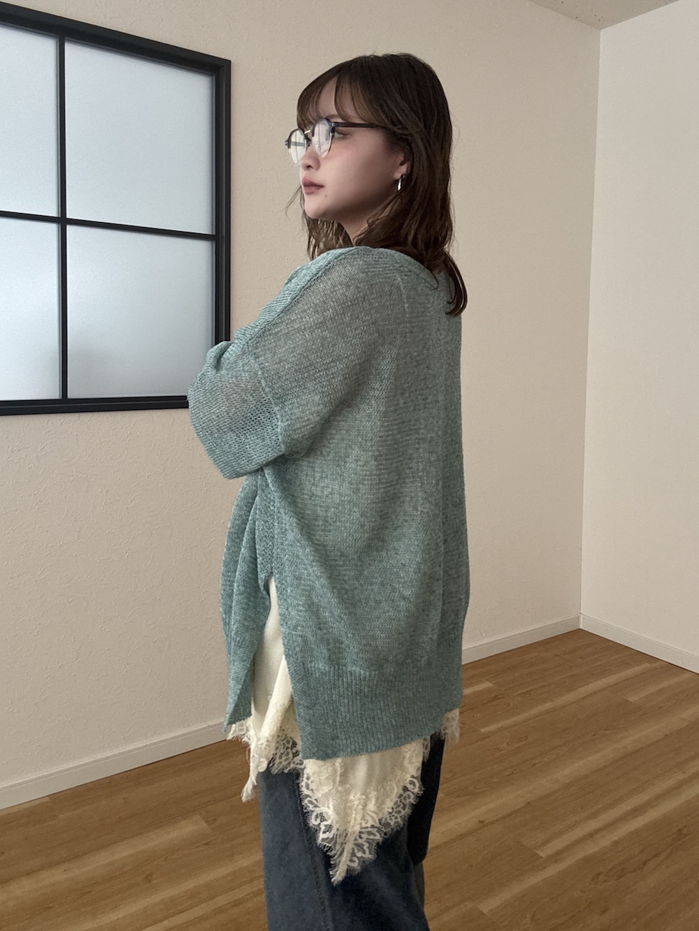 グリーン系のカーディガン/ボレロ、ブルー系のデニムパンツを着用したレディースの春コーディネートの3枚目の写真