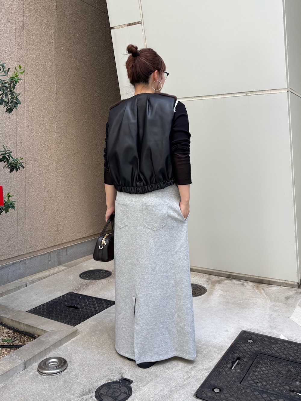 グレー系のワンピース、ブラック系のTシャツ/カットソー、ブラウン系のベストを着用したレディースの夏コーディネートの3枚目の写真