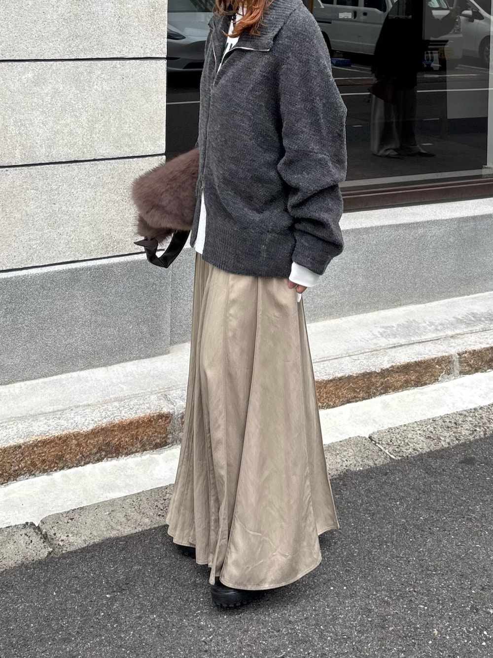 グレー系のカーディガン/ボレロ、ベージュ系のスカート、ブラウン系のショルダーバッグを着用したレディースの秋コーディネートの4枚目の写真