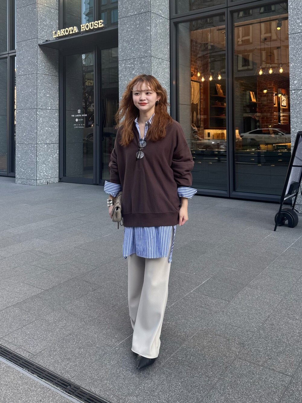 ブラウン系のスウェット、ブルー系のシャツ/ブラウス、ホワイト系のスラックスを着用したレディースの冬コーディネートの4枚目の写真