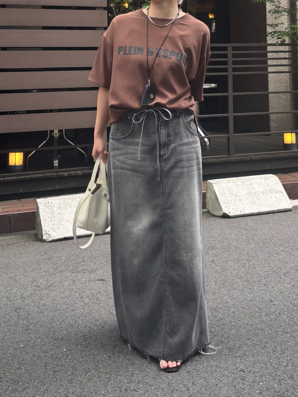 ブラック系のスカート、ブラウン系のシャツ/ブラウス、ホワイト系のショルダーバッグを着用したレディースの夏コーディネートの5枚目の写真